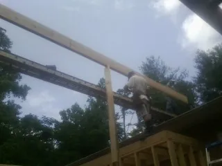 Carpenter setting a ridge beam over a new addition frame — Ice Dam Removal by Roofing Brothers in East Nassau