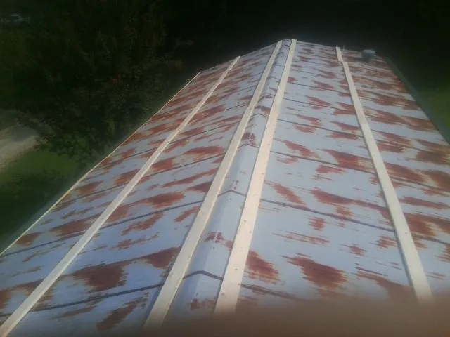 Rusted metal roof panels with new wood purlins before replacement — Storm Damage Roof Repair in East Nassau by Roofing Brothers