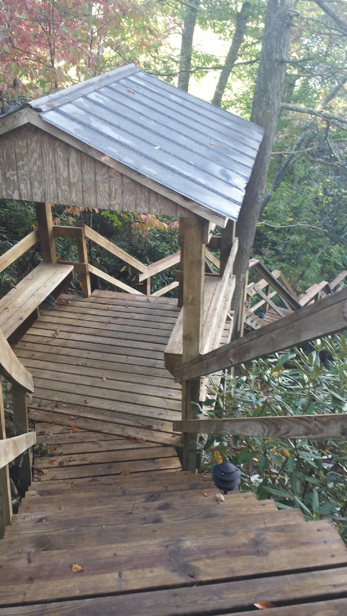 Metal roofed shelter over wooden steps on a wooded walkway — Skylight Repair & Installation work by our crew in East Nassau